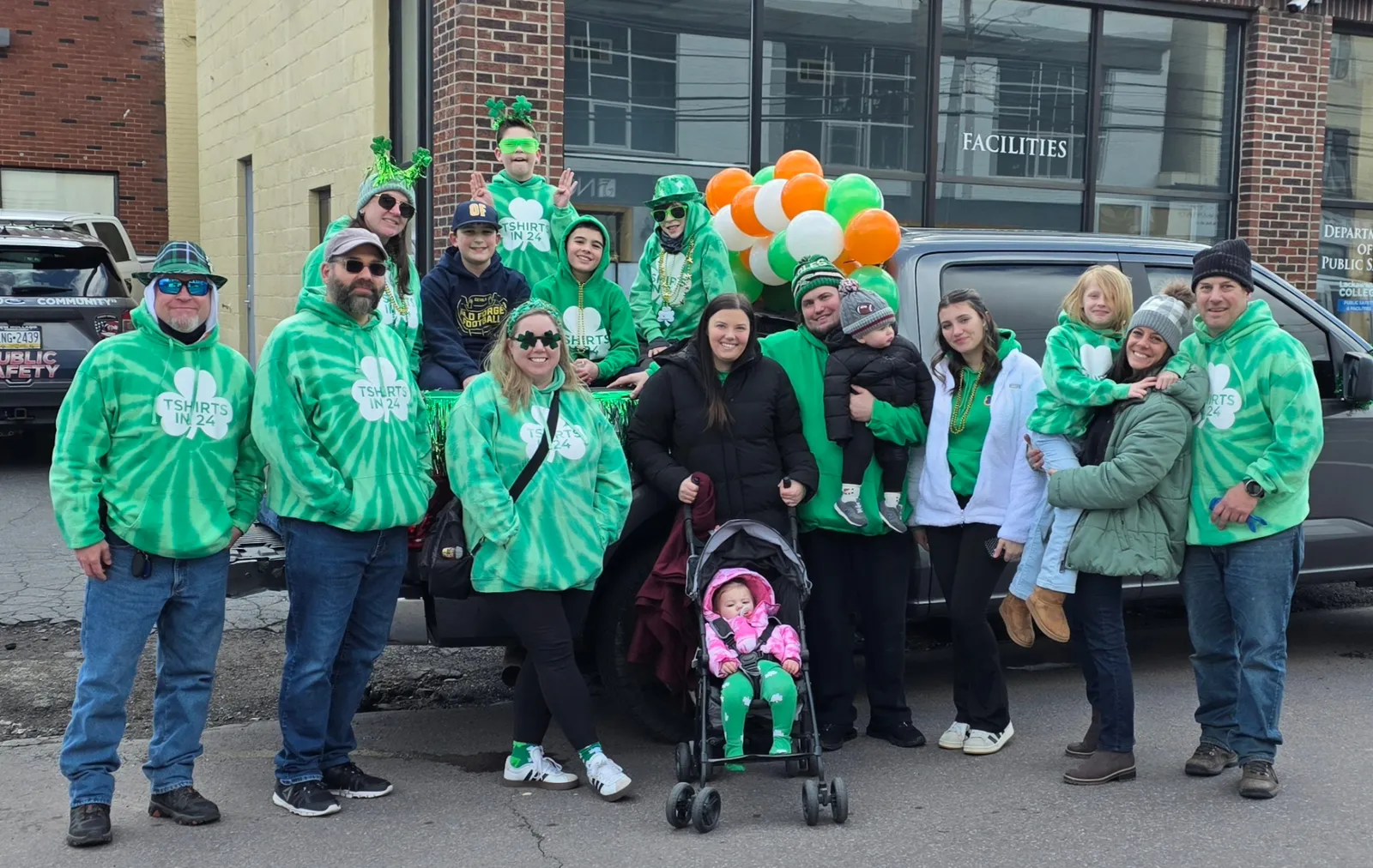 T Shirts in 24 crew and families in matching green tie-dye TShirts In 24 hoodies at the St. Patrick's Day parade